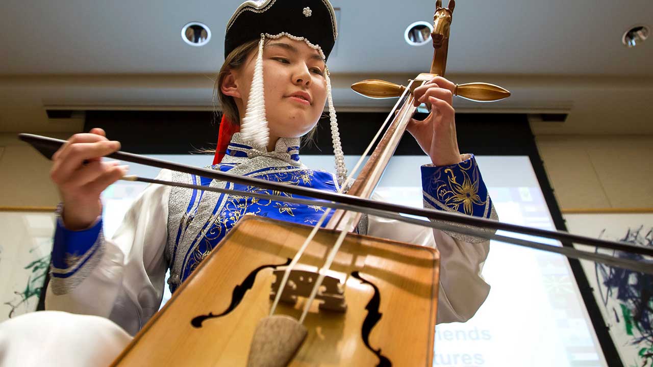 student playing a stringed instrument with a bow