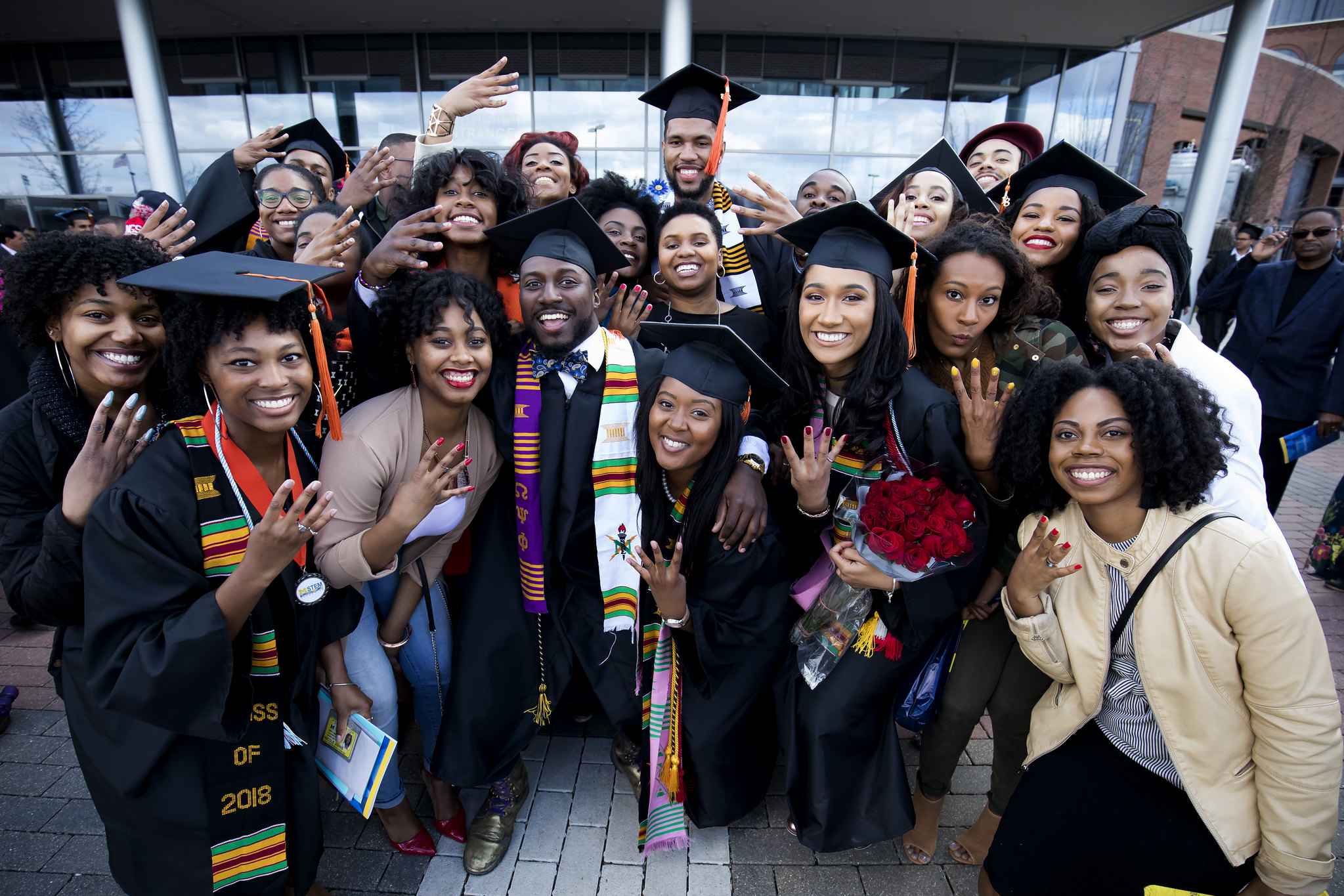 large group of smiling graduates in caps and gowns