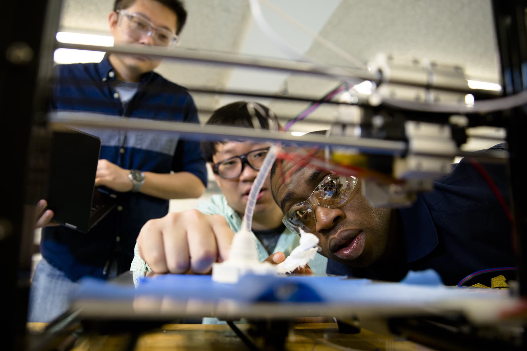 professor observes two students making technical adjustments