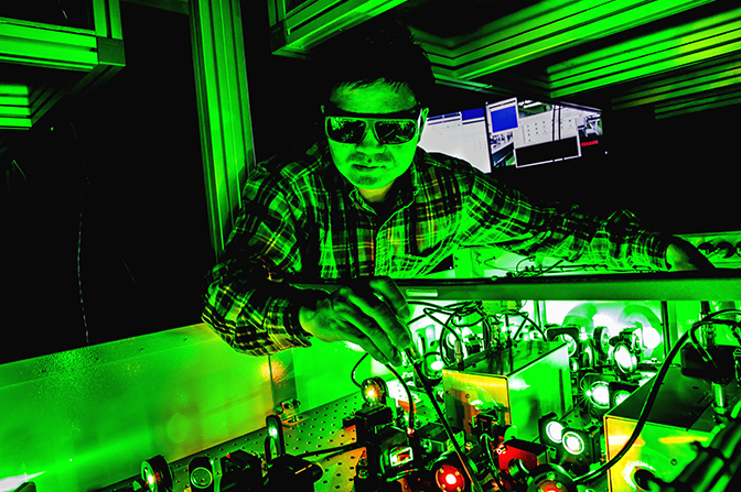 scientist standing over light conversion apparatus