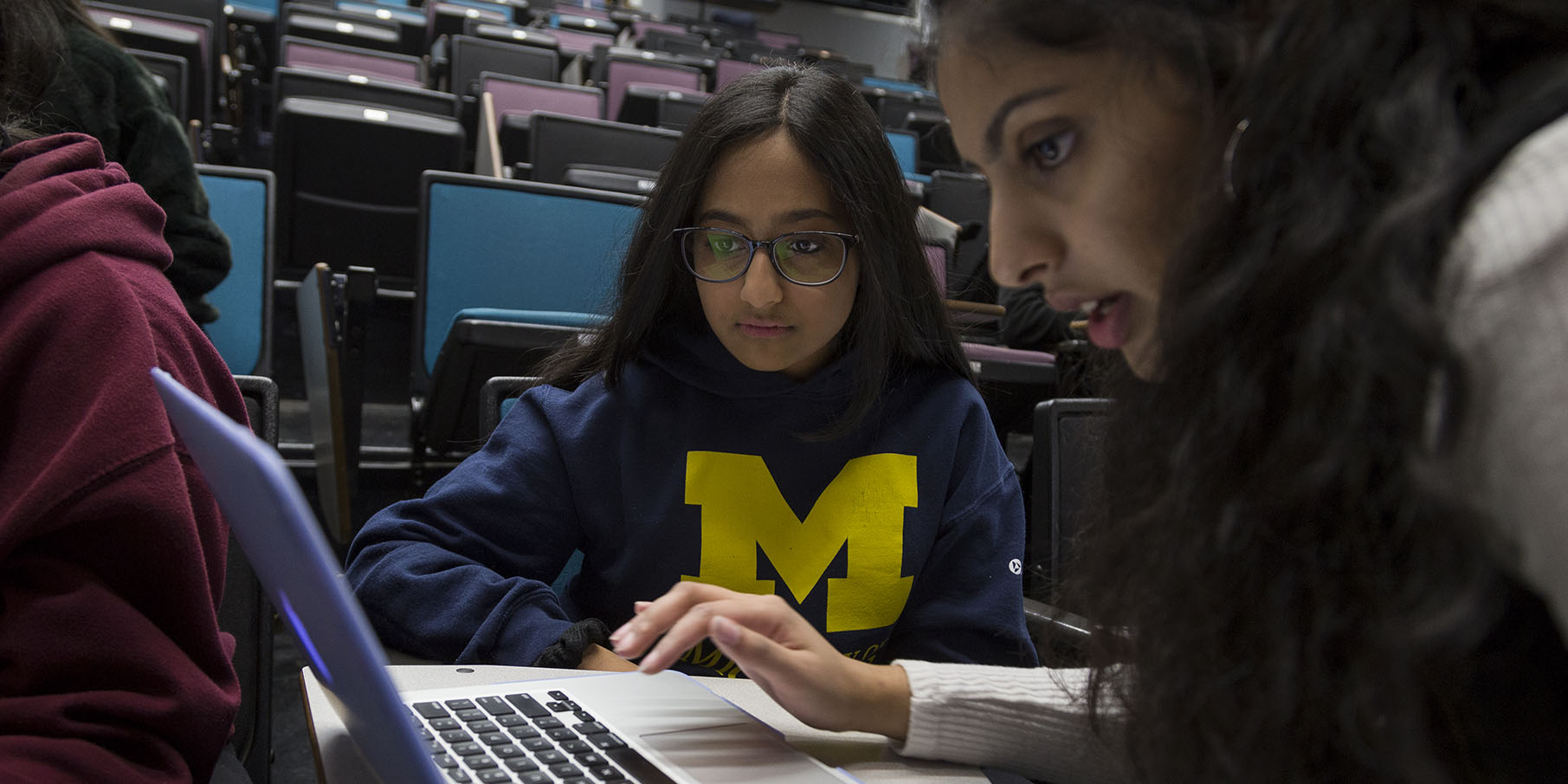 Two students work on a laptop.