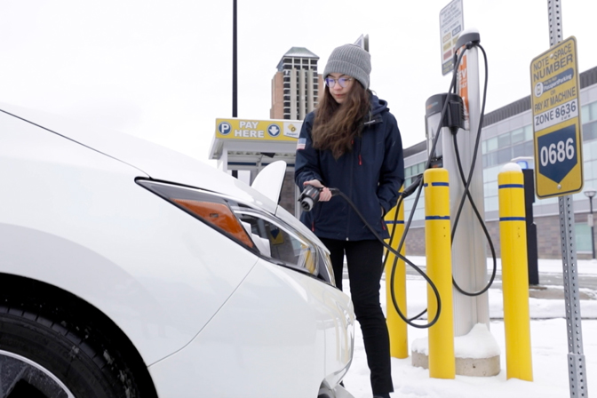 Engineering student Chloe Acosta plugs in an EV on the University of Michigan’s North Campus. Acosta is also powertrain director on the MRacing team, which recently switched to an electric powertrain.
