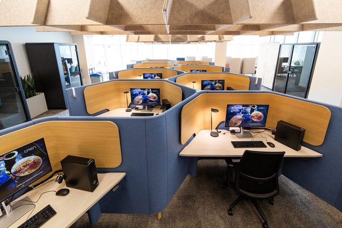 The inside of the CAEN Quiet Lab. There are many desks with privacy walls for students to work. Around the perimeter of the room, there are focus pods for students.