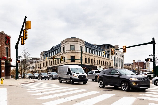 cars moving through an intersection in a busy downtown area