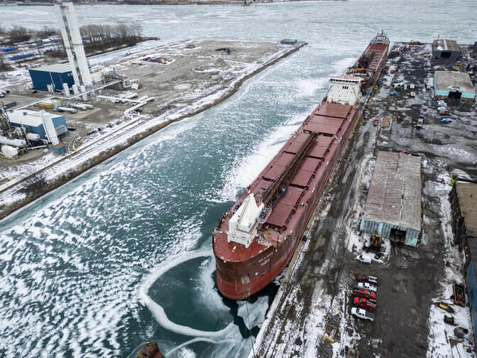 The red-orange hull of the Mark W. Barker stretches over 600-feet along a dock.
