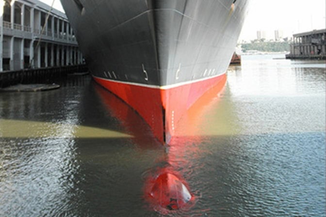 The famous Queen Mary 2 in the water with the bulbous bow visible.